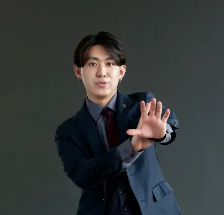 Magician performing a sleight of hand trick, dressed in a suit and using precise hand gestures.